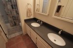 En suite in the main bedroom offers a dual vanity and tub shower combination